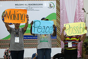 MPI Training Participants holding signs Making Peace Possible